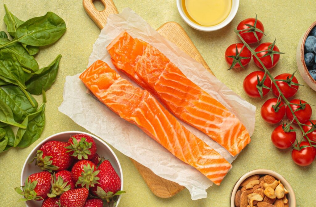 Healthy foods for skin such as salmon, strawberries, tomatoes, nuts, and spinach