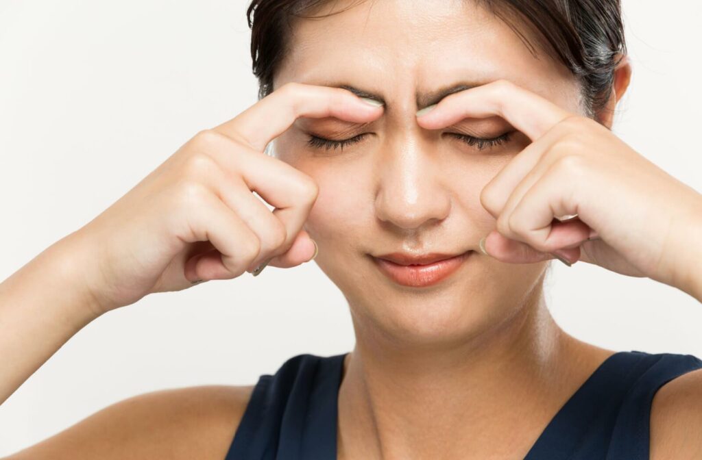 A person holding thei reyelids to stop them from twitching